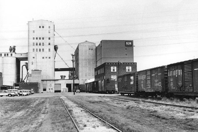 Rail cars with markings of BNSF predecessors Burlington Northern (BN) and Chicago, Burlington & Quincy Railroad (CB&Q) outside the mill in an undated photo taken 1970 or later. Rail cars with markings of BNSF predecessors Burlington Northern (BN) and Chicago, Burlington & Quincy Railroad (CB&Q) outside the mill in an undated photo taken 1970 or later.